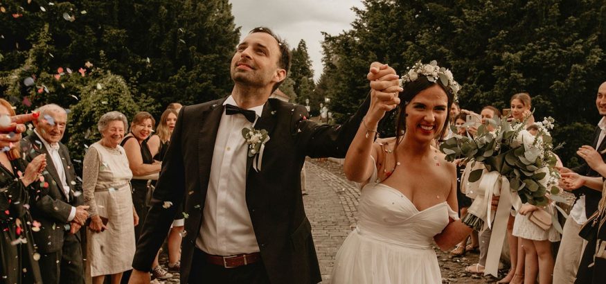 front-view-of-happy-newlywed-couple-walking-throug-min